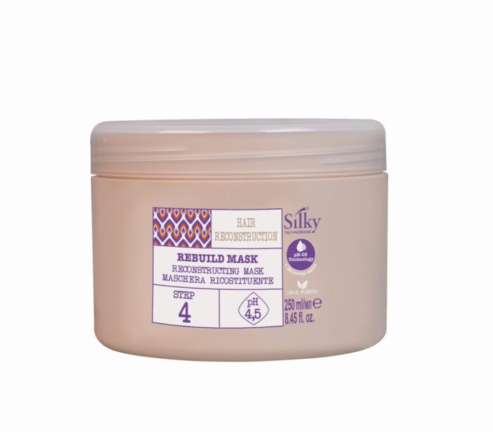 En beige behållare märkt "SILKY HAR REBUILD MASK 500ML" för hårrekonstruktion, med steg 4, pH 4,5. Designad för både män och kvinnor, den har ett litet mönster och flerspråkig text, en del av Silky Sveriges hårprodukter.